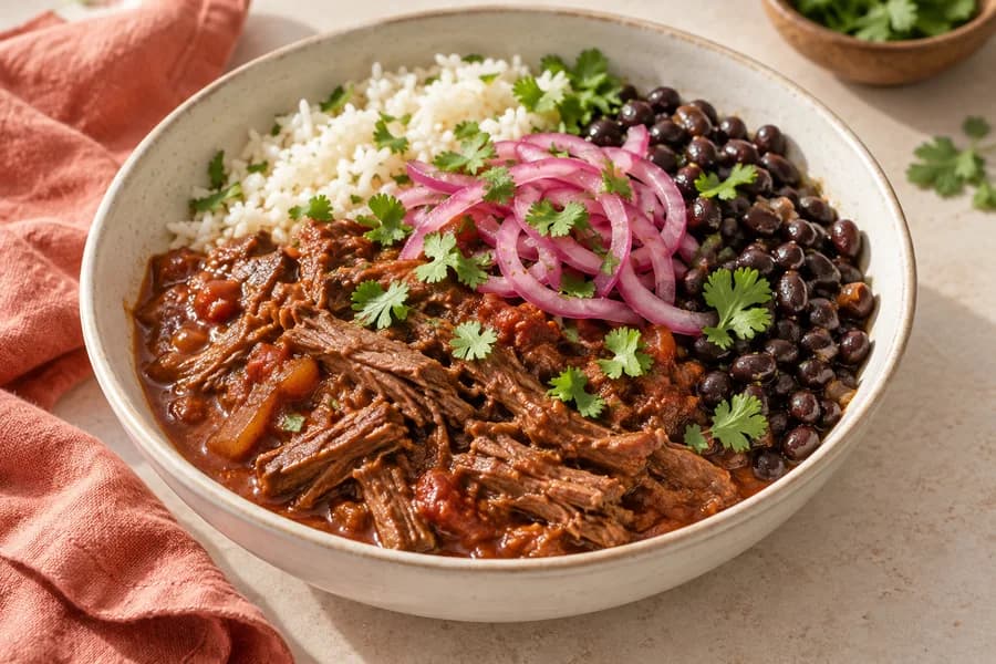 Braised beef and rice with black beans and pickled red onions.